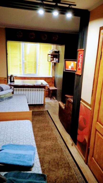a room with two beds and a television in it at Небольшая СТУДИЯ, проспект ЦЕНТРАЛЬНЫЙ 124А, 2 дивана, 2 кресла 3 этаж 9 этажного дома Wi-Fi in Mykolaiv