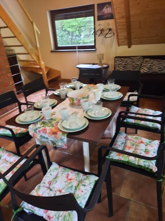 a table with chairs and plates and cups on it at Mariolka Skorzęcin in Skorzęcin
