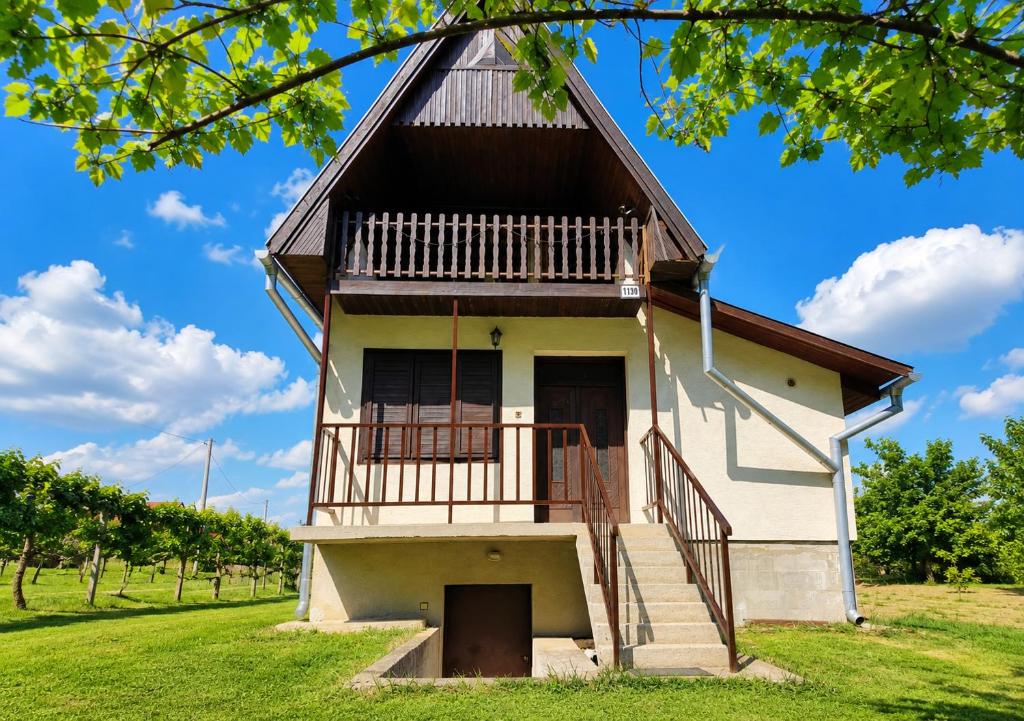 a building with a balcony and stairs in a field at Chata Leonard in Farná