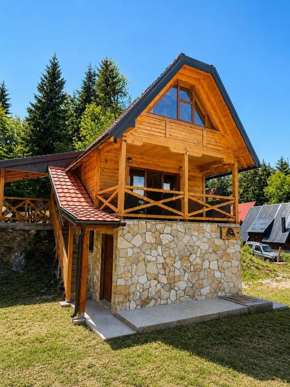 a large wooden house with a bench on top of it at Brvnara Tarska Zora in Sekulić 