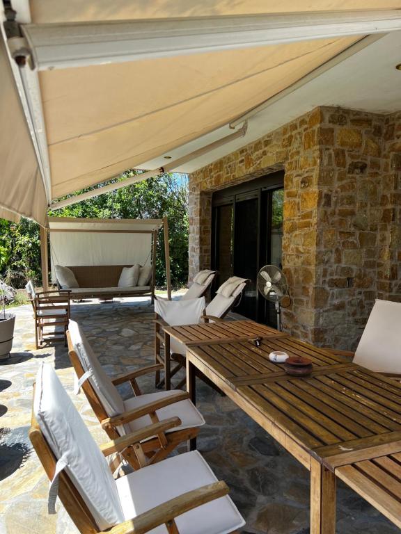 an outdoor patio with a wooden table and chairs at Country Vila in Nikiti