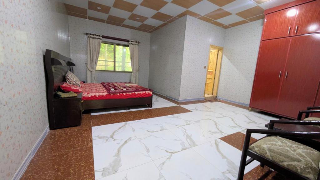 a bedroom with a red bed and a large marble floor at Afridi Apartment in Murree