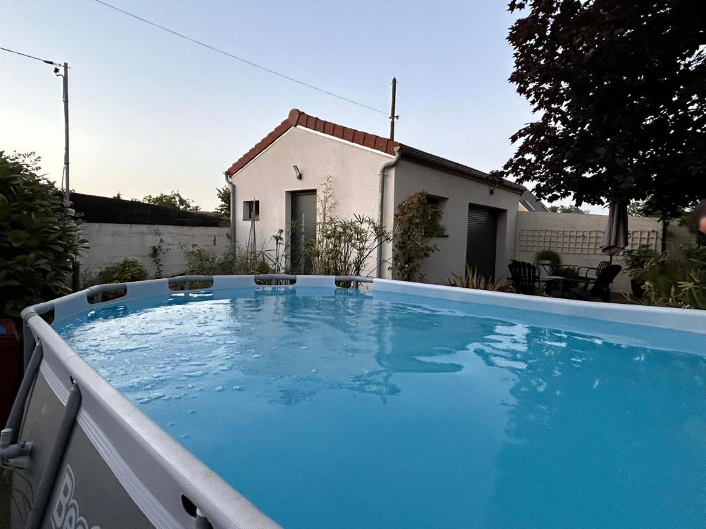 a large blue swimming pool in front of a house at Le Bulloire in Montlouis-sur-Loire