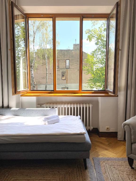 a bedroom with a bed and a large window at Spacious Old Town Apartment, 3 Rooms, Free Parking, Sleeps up to 7 in Kaunas