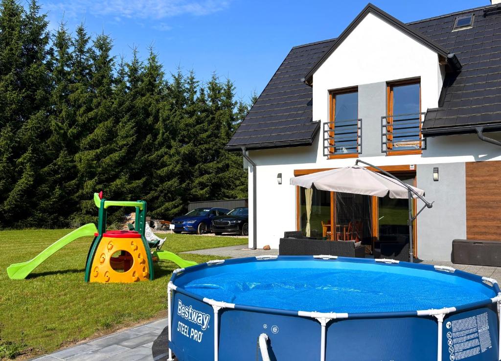 a pool in a yard next to a house at Mazury w Zasięgu in Brajniki