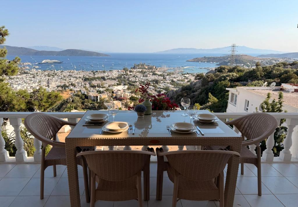a table on a balcony with a view of the city at BODRUM BURCU VILLA , Magnificent Sea View, Cozy, Free Otopark, Free Wifi in Bodrum City