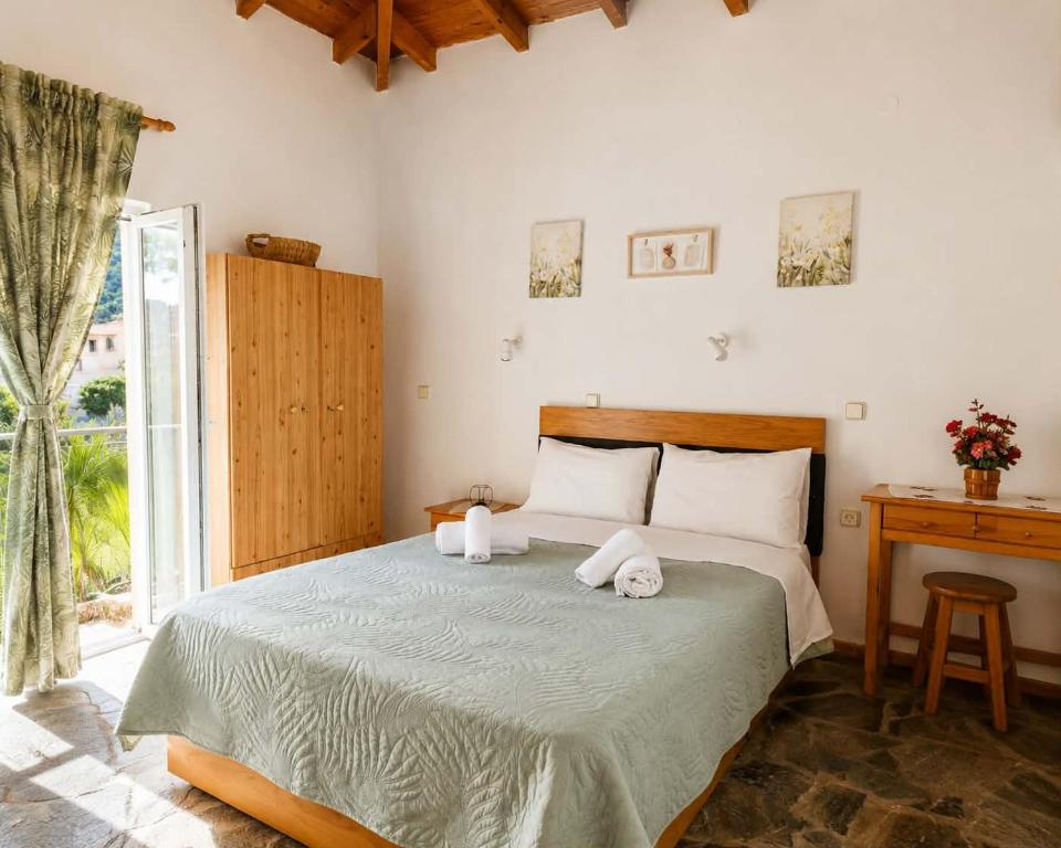 a bedroom with a bed with two towels on it at Oasis Studios Skala Kallonis in Skala Kallonis