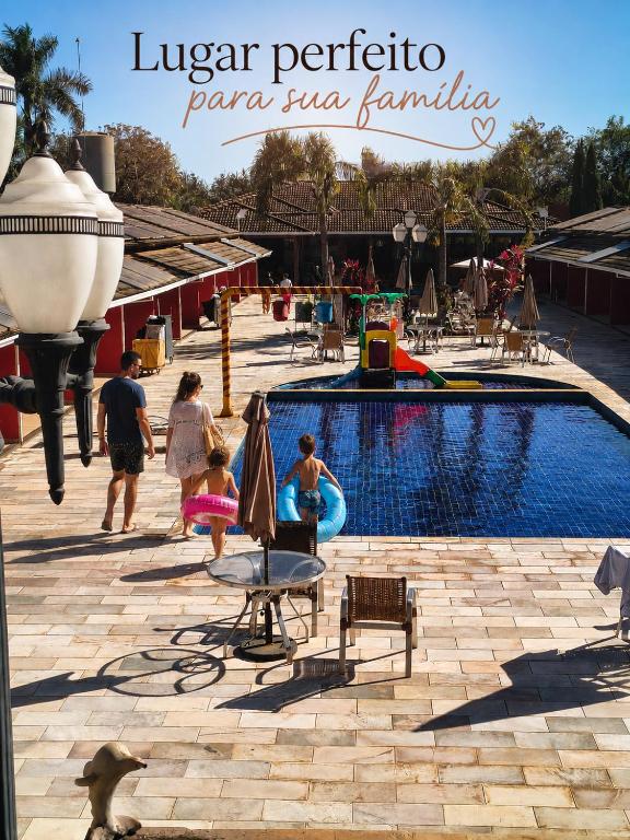 a group of people playing in a pool at a resort at Hotel Pousada Villa Itália Olímpia in Olímpia