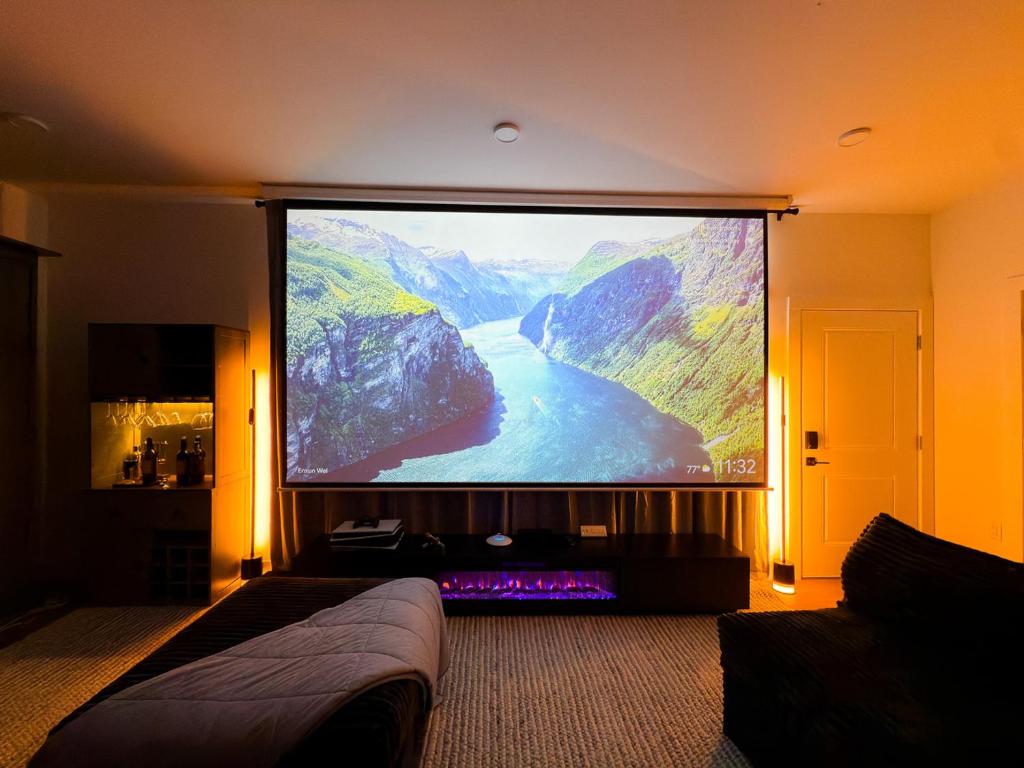 a large projection screen in a room with a bed at 1 Block to Beach 150" Theater PS5 Arcade in Seaside Heights