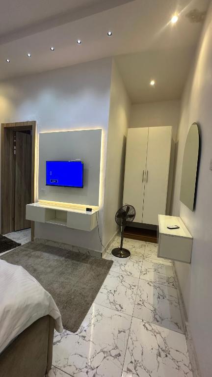 a bedroom with a bed and a tv on a wall at Emilomo beautiful homes in Cardoso
