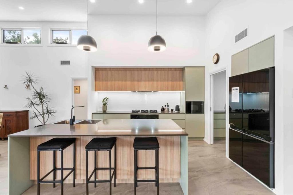 a kitchen with a large island with bar stools at Tomakin Tonic in Tomakin