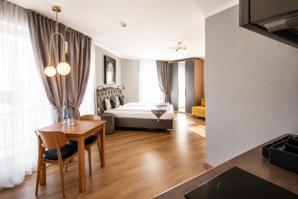 a living room with a bed and a table in a room at Boardinghouse City Home - Living in Bielefeld