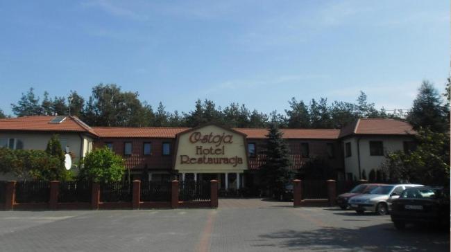 un edificio de hotel con coches aparcados en un aparcamiento en Hotel Ostoja, en Lipówki