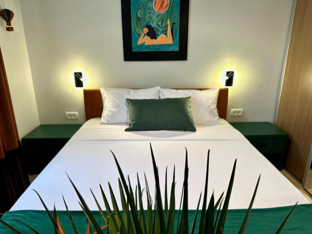 a bed with white sheets and green pillows in a bedroom at Art-Villa SeLena in Bar