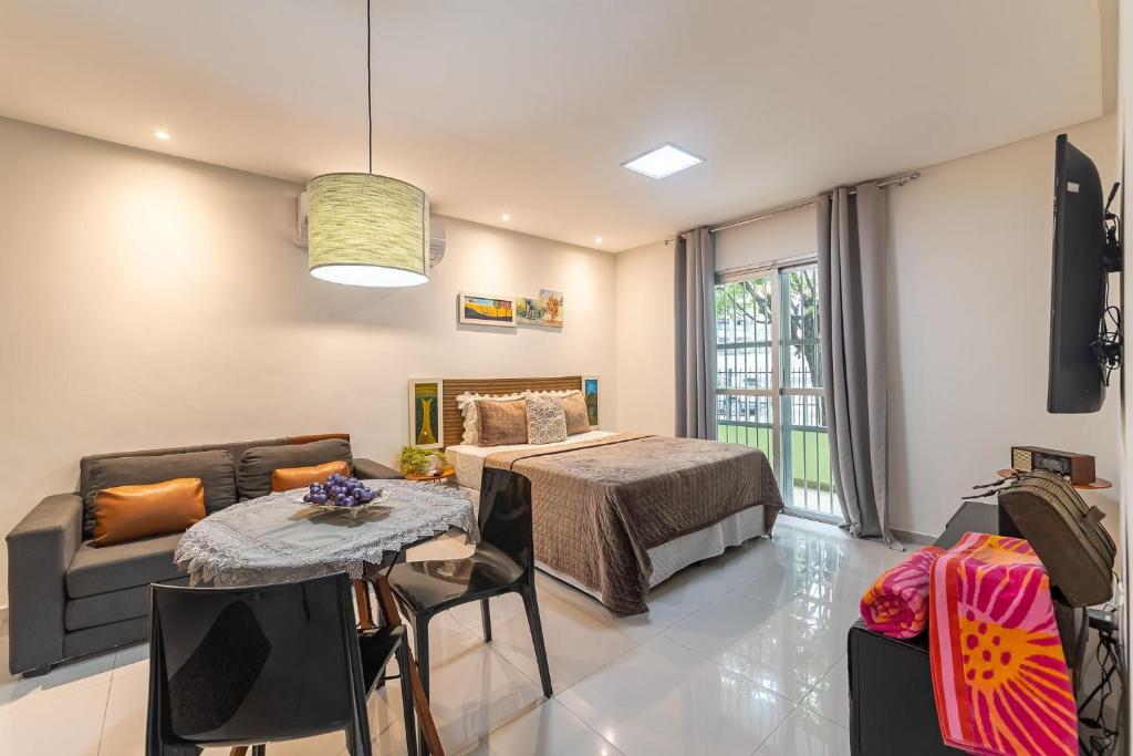 a room with a bed and a table and a couch at Apartamentos com internet rápida in Maceió