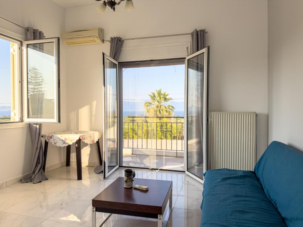 a living room with a blue couch and a table at Modern Sea View Apartment - Arkitsa Rentals in Arkitsa