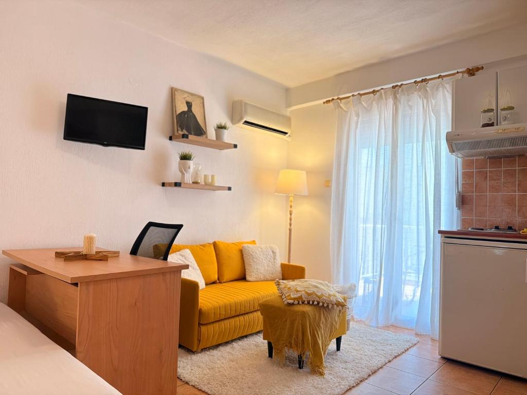 a living room with a yellow couch and a table at Studio 28 in Chios