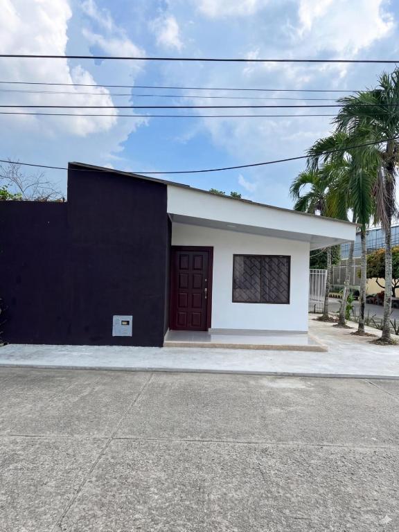 a black and white building with a red door at Cerete Apartment 111 in Cereté