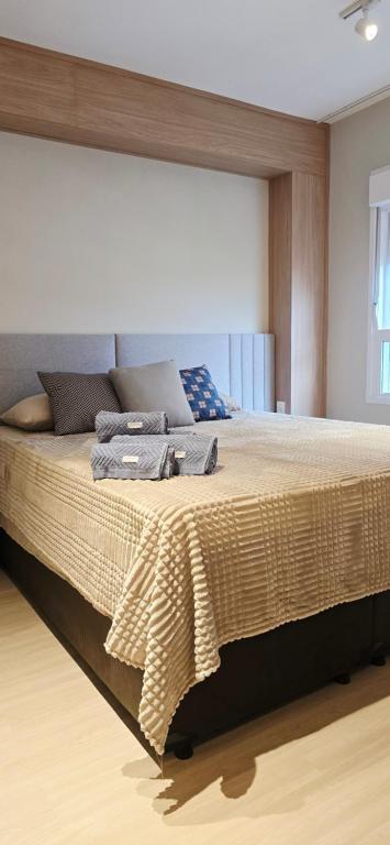 a bedroom with a large bed in a room at Apê Brisa-5min consulado EUA-garagem in Porto Alegre
