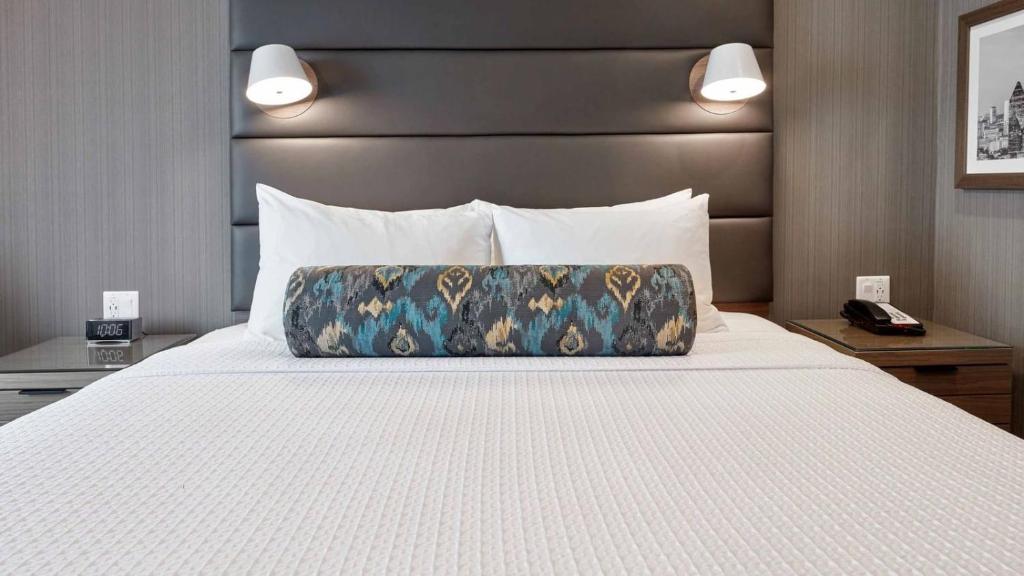 a bed in a hotel room with a pillow on it at Zemira Apartments in Abuja