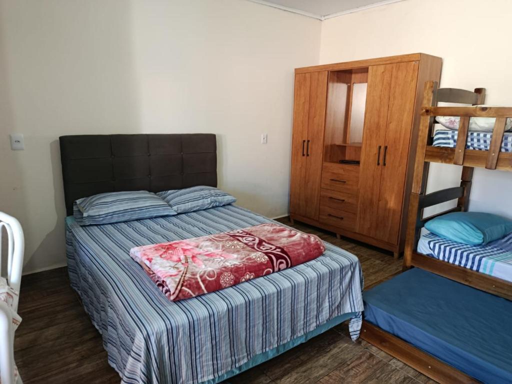 a bedroom with two bunk beds and a cabinet at Pousada Paraiso in Telêmaco Borba