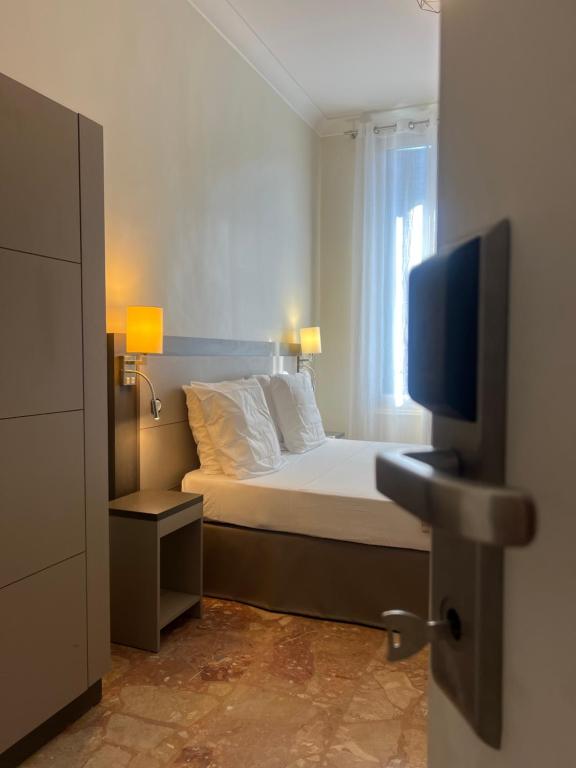 a bedroom with a bed and a flat screen tv at Chambre meublée in Nice