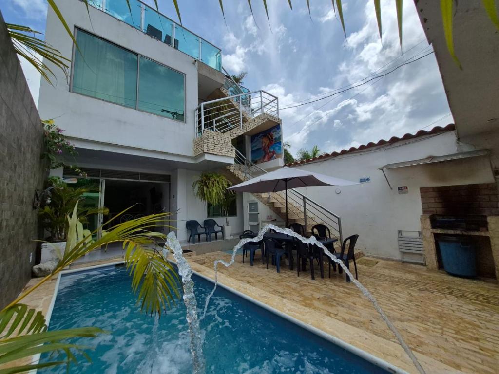 a villa with a swimming pool and a house at Casa Playa Arreboles in Cartagena de Indias
