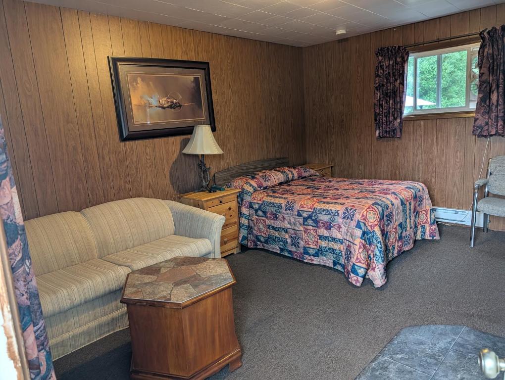 a hotel room with a bed and a couch at Lang's Motel in Wabigoon