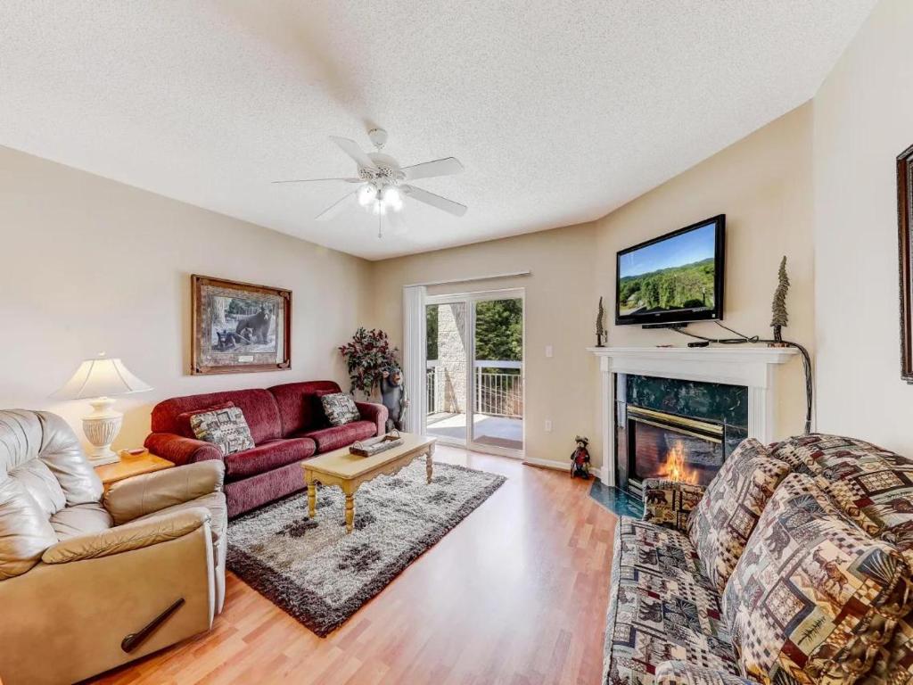 a living room with a couch and a fireplace at Whispering Pines 111 Lazy Bear in Pigeon Forge