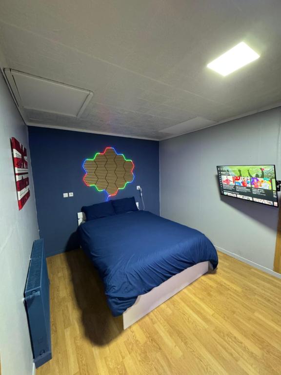 a bedroom with a bed in a blue wall at Studio St Florentin 2 in Saint-Florentin