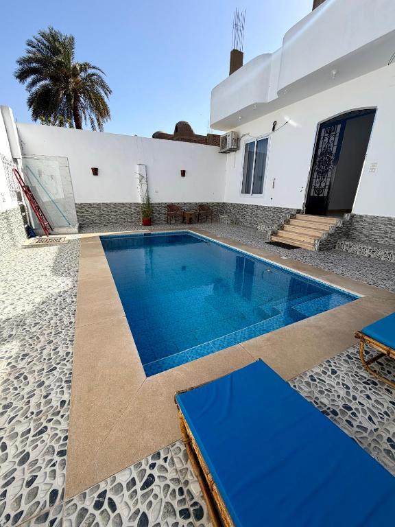 a swimming pool in front of a house at El-Rabee Hotel in Al Aqālitah