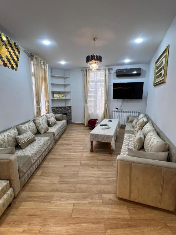 a living room with a couch and a tv at مفروشة السعادة in Tlemcen