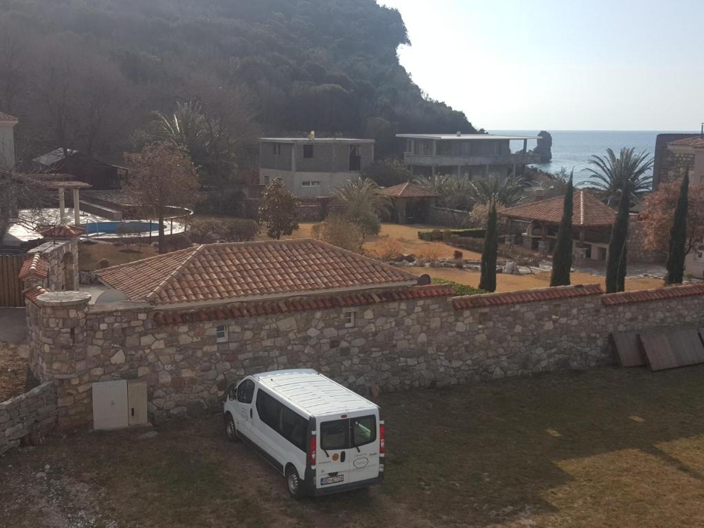 a white van parked in front of a stone wall at Buljarica Bay Apartments in Petrovac na Moru