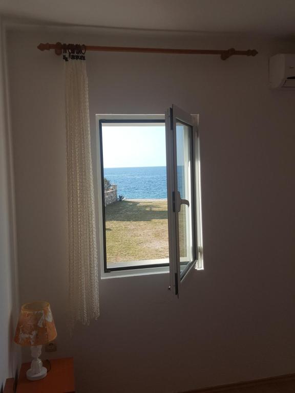 a window in a room with a view of the ocean at Buljarica Bay Apartments in Petrovac na Moru