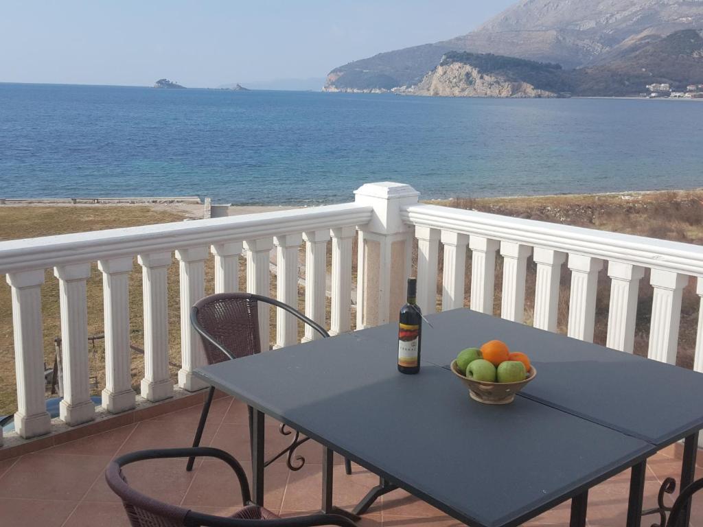 a table with a bowl of fruit on a balcony at Buljarica Bay Apartments in Petrovac na Moru