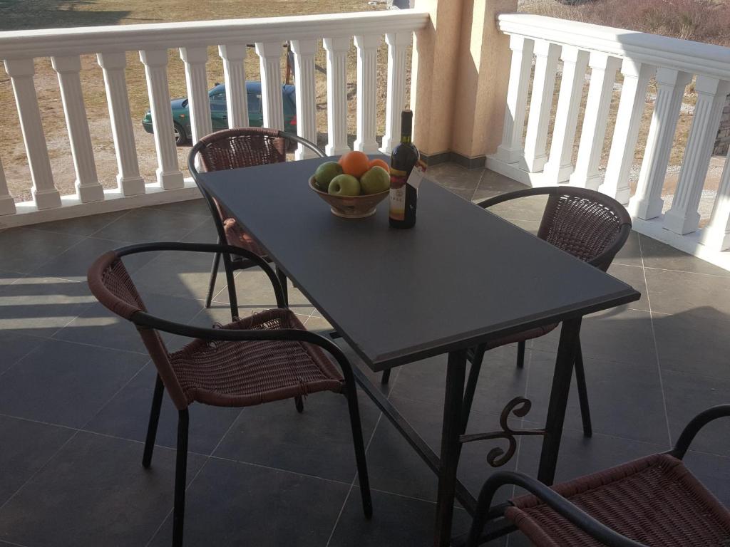 a table with a bowl of fruit on a balcony at Buljarica Bay Apartments in Petrovac na Moru
