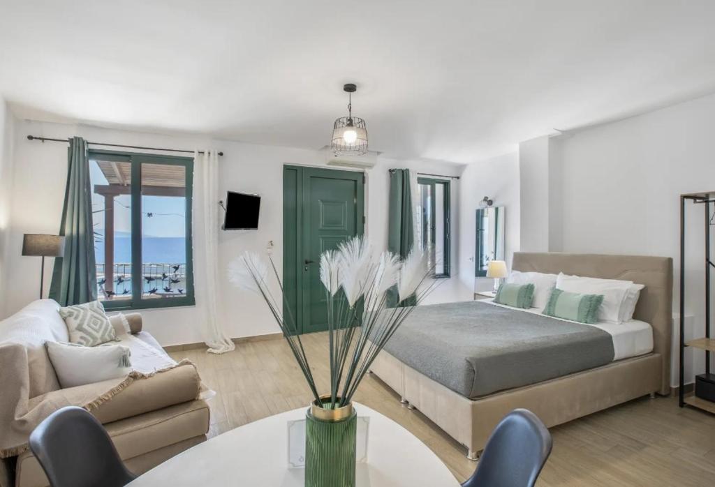 a bedroom with a bed and a table and a couch at Akteon Rooms in Agia Galini