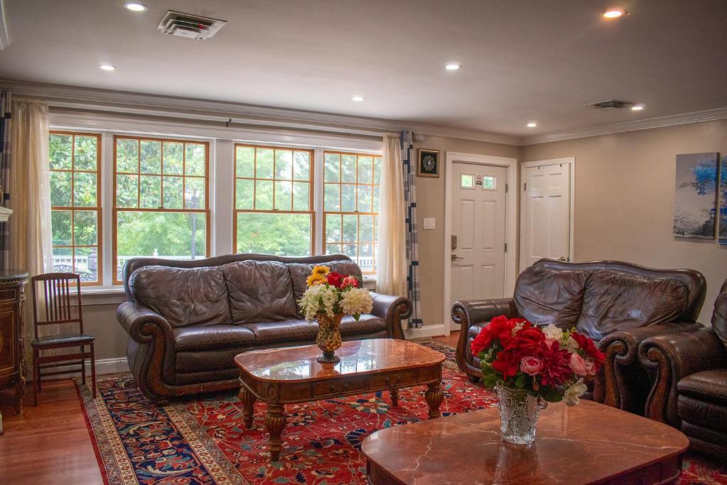 a living room with leather couches and a table at National Harbor Guesthouse in Fort Washington