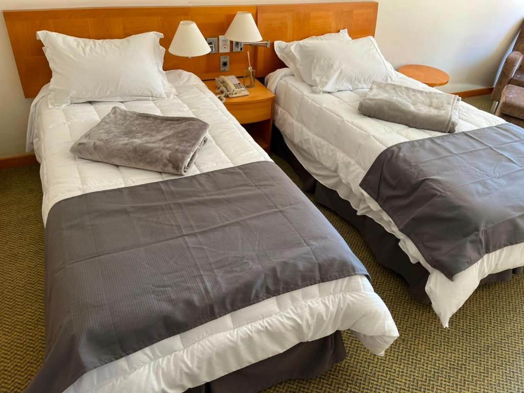 a hotel room with two beds and a table at StudioTriplo Superior Completo 608- Casal e Solteiro ou 3 Solteiros in Barueri