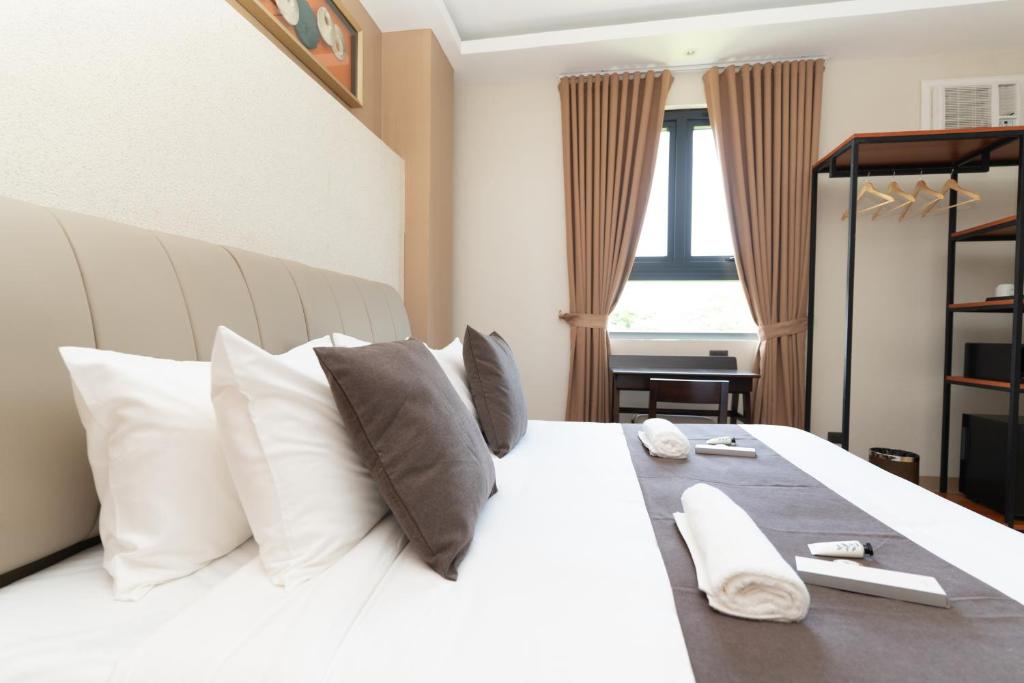 a bedroom with a large white bed with white pillows at Hotel Philippe Palo in Palo
