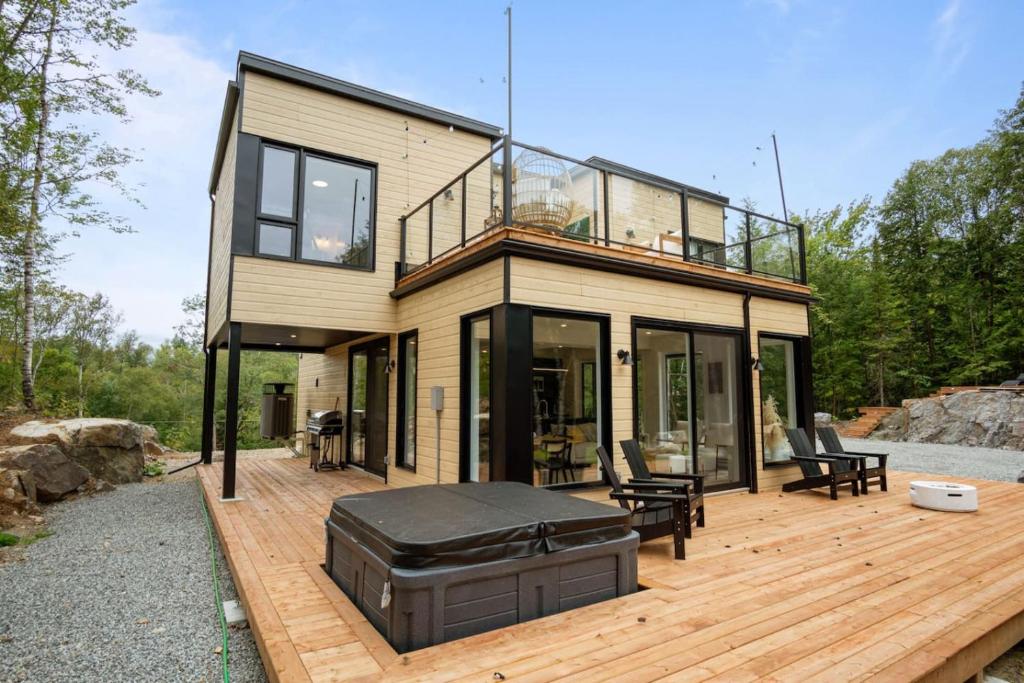 a house with a large deck with a grill at Ultra Luxurious Modern Chalet Private Jacuzzi in La Conception