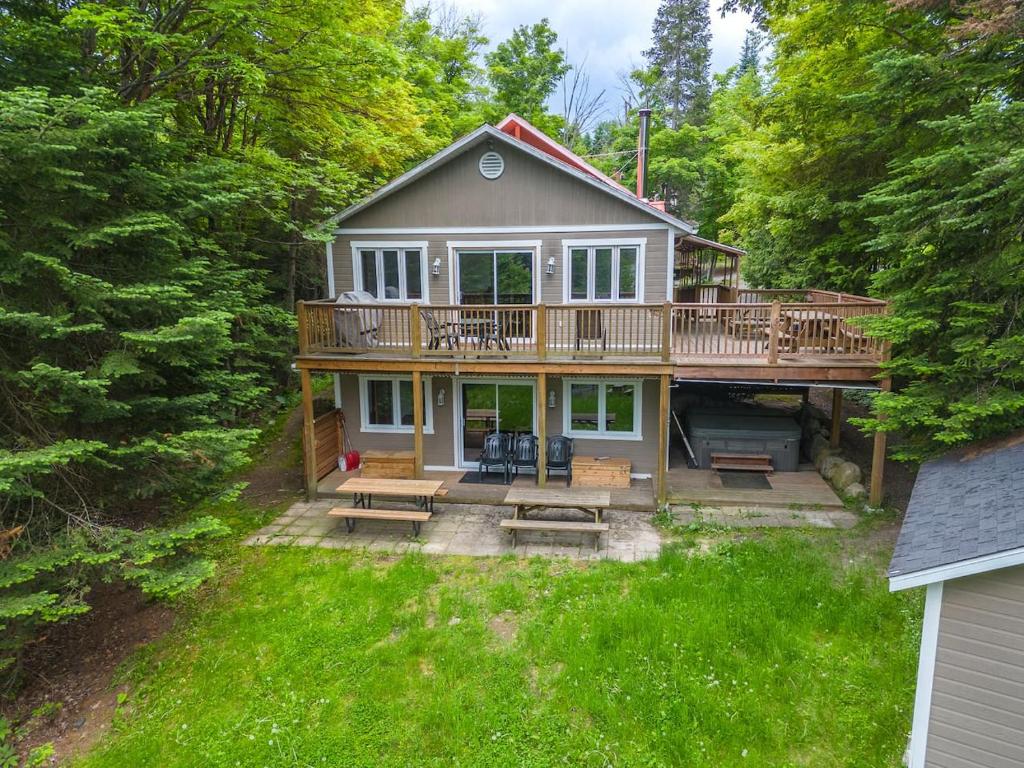 a large house with a deck in the woods at Rustic & Charming Mont Blanc Chalet Private Spa in Saint-Faustin