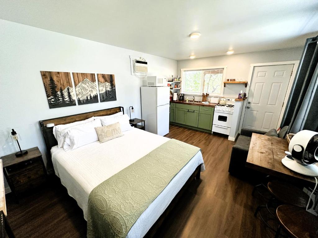 a bedroom with a large bed and a kitchen at The Hut at Deer Hollow in Three Rivers