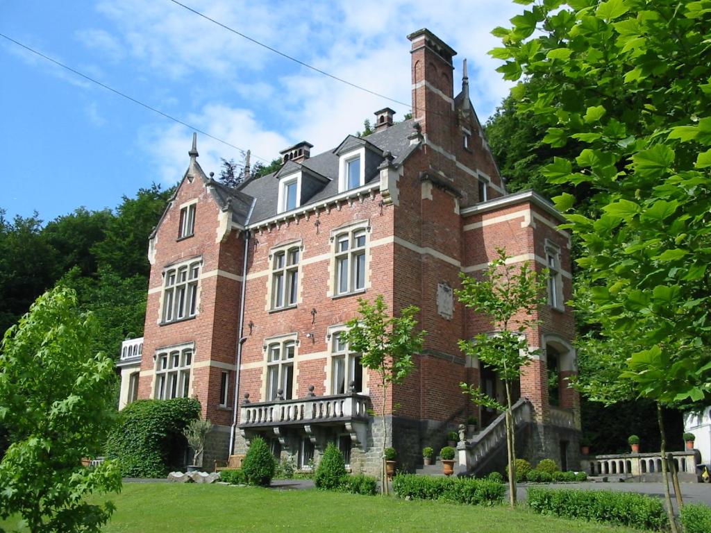 ein großes rotes Backsteingebäude mit einem Turm in der Unterkunft New-Castle in Spa