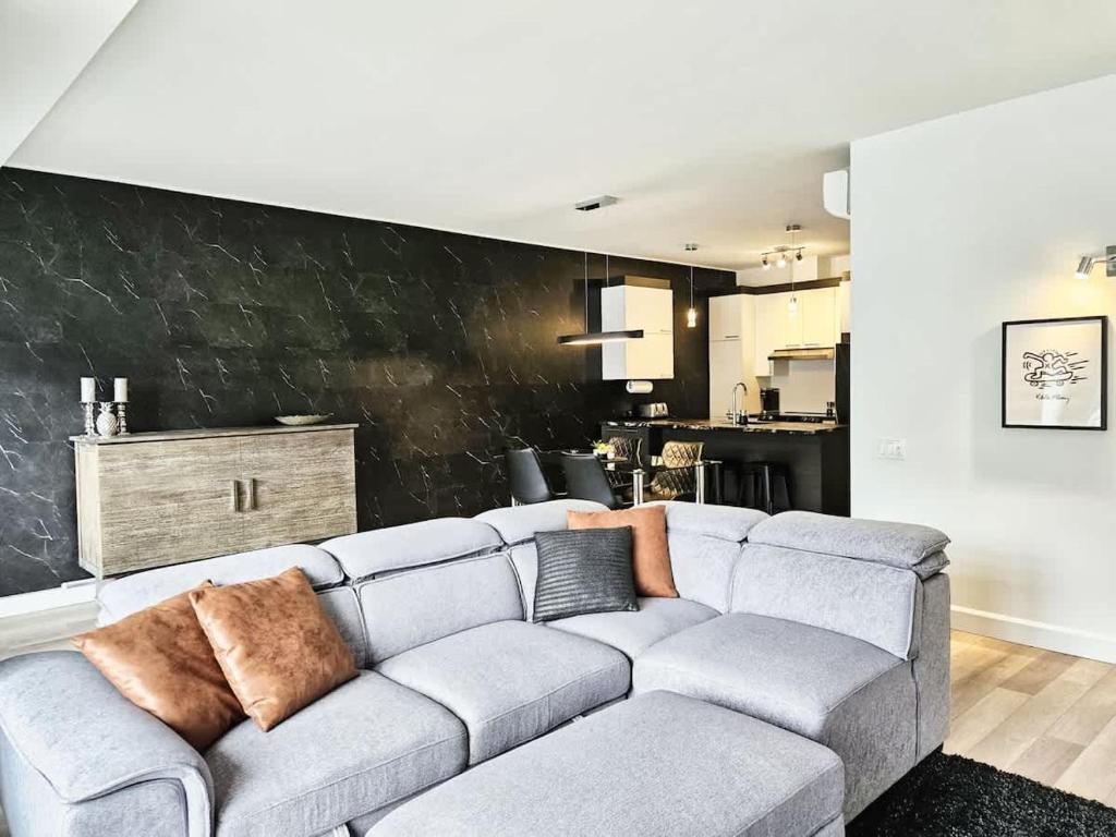 a gray couch in a living room with a black wall at Le201 Condo Chic Free Parking in Quebec City