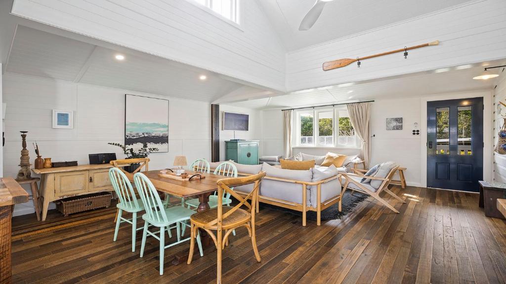 a dining room and living room with a table and chairs at 19 Newry St in Nambucca Heads