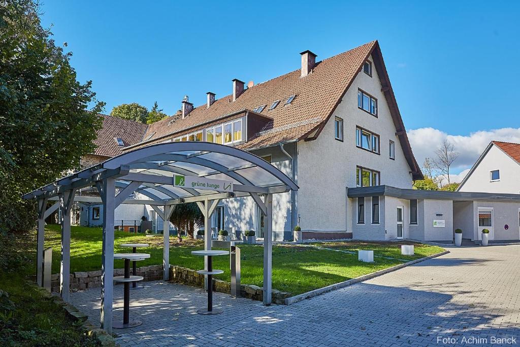 einem Pavillon vor einem großen Haus in der Unterkunft Waldhotel Brand's Busch in Bielefeld