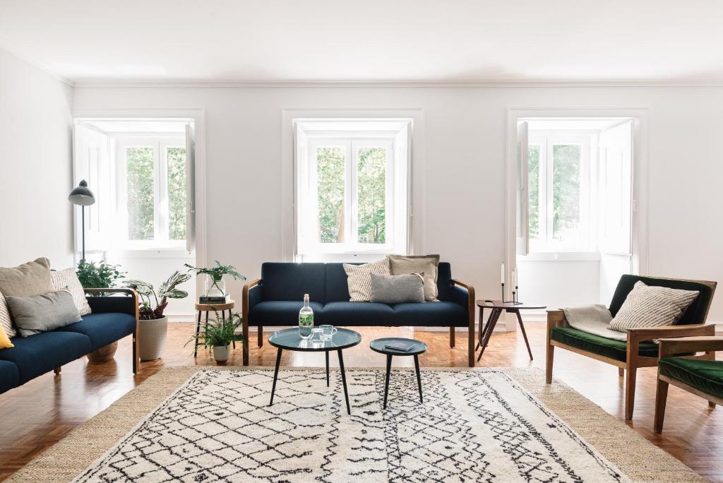 una sala de estar con sofás azules y una mesa. en Casa C'Alma, en Lisboa