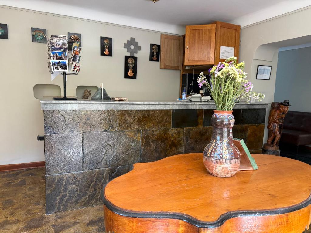 a vase of flowers on a table in a kitchen at La Quinta Eco Hotel in Urubamba