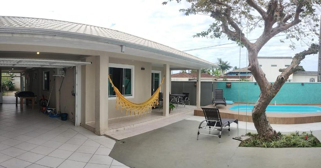 a house with a patio with a hammock and a pool at Res Praia e Sol litoral do Pr Matinhos in Matinhos
